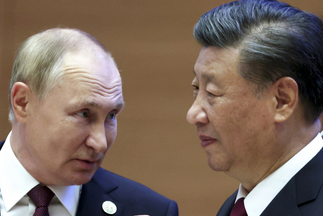 시진핑(오른쪽) 중국 국가주석이 16일(현지 시간) 우즈베키스탄 사마르칸트에서 개최된 상하이협력기구(SCO) 정상회의에 참석해 블라디미르 푸틴 러시아 대통령 옆을 지나가고 있다. AP연합뉴스