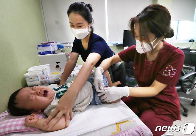21일 오전 대전의 한 병원에서 생후 10개월된 영아가 독감백신을 맞고 울음을 터뜨리고 있다.