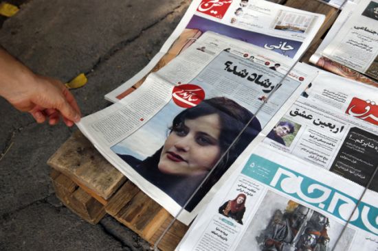 이란 수도 테헤란 거리에 마흐사 아미니가 히잡을 제대로 착용하지 않은 혐의로 도덕경찰에 구금됐다가 사망한?사건을 보도하는 일간지가 놓여있다. 사진=EPA 연합뉴스