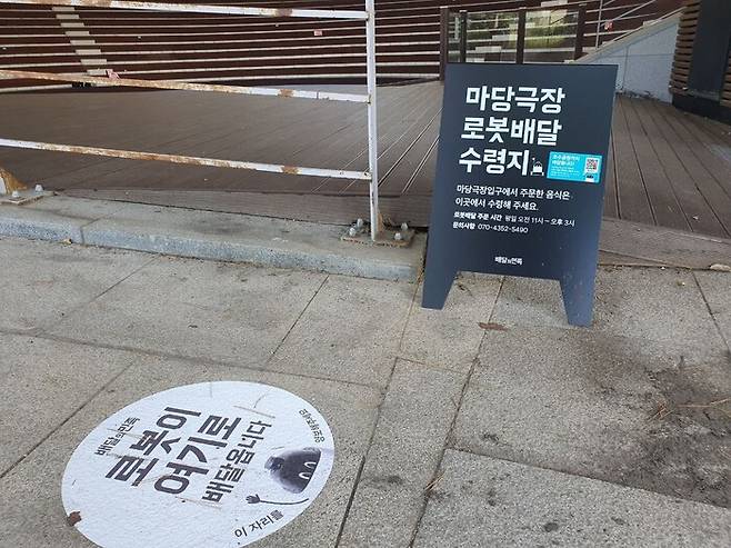 경기도 수원 광교호수공원 안에 배달 로봇 음식 수령지 안내판이 설치돼 있다. 옥기원 기자