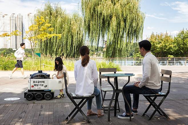 배달의민족이 운영하는 배달 로봇이 경기도 수원 광교호수공원에서 음료를 배달하고 있다. 배달의민족 제공