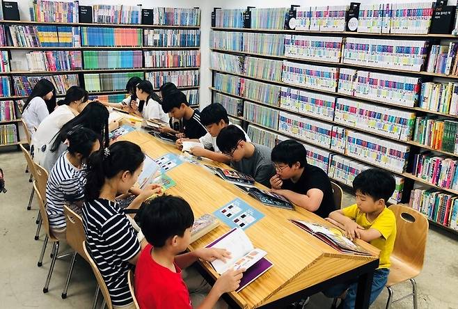 2019년 7월7일 서울의 한 중고서점에서 부모와 자녀가 함께 책을 고른 뒤 내용을 살펴보고 있다. 문해력은 수능 등 대입 시험뿐 아니라 아이들이 졸업 뒤 ‘평생 독자’로 살아가는 데 큰 영향을 끼친다. 김지윤 기자