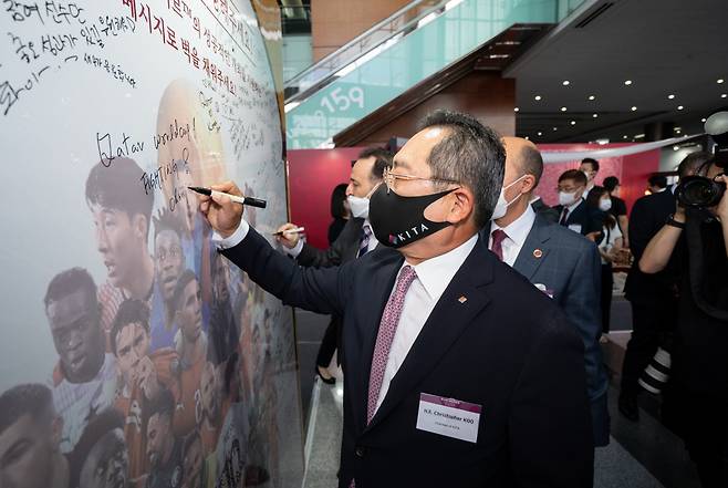 Korea International Trade Association (KITA) chairman, Christopher Koo writes a message to cheer up for Qatar World Cup 2022 at Coex lobby in southern Seoul on Monday.((Korea-Arab Society)