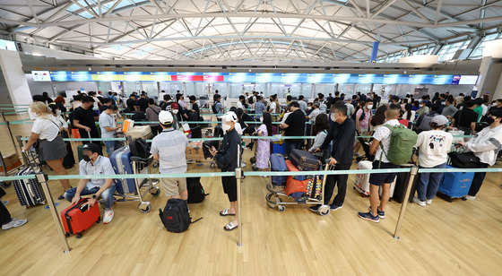 Travelers line up at Incheon International Airport. [YONHAP]