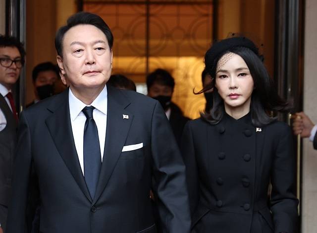 검은색 정장 차림의 윤석열 대통령과 김건희 여사가 19일 엘리자베스 2세 여왕의 장례식에 참석하기 위해 런던의 한 호텔을 나서고 있다. 김 여사가 검은 베일이 달린 모자를 쓰면서 온라인에서 논란이 됐다. [연합]