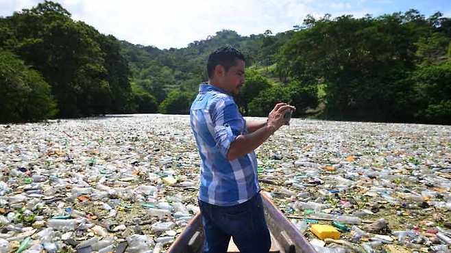 발전소 직원이 배를 타고 쓰레기가 가득한 호수의 사진을 찍고 있다. 디아리오데오이