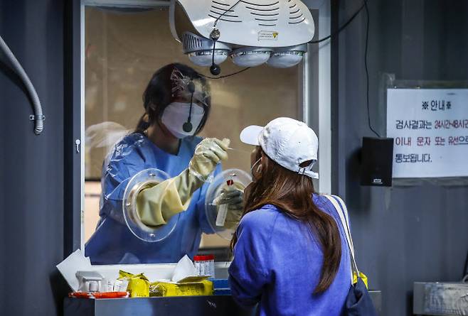 0시 기준 국내 코로나19 신규확진자가 4만 1286명으로 집계된 21일 오전 서울 용산구보건소 선별진료소를 찾은 시민이 코로나19 검사를 받고 있다. (사진=뉴시스)
