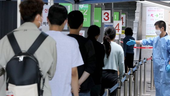 22일 오전 서울 용산구보건소 신종 코로나바이러스 감염증(코로나19) 선별진료소를 찾은 시민들이 검사를 받기 위해 줄을 서고 있다. 뉴스1