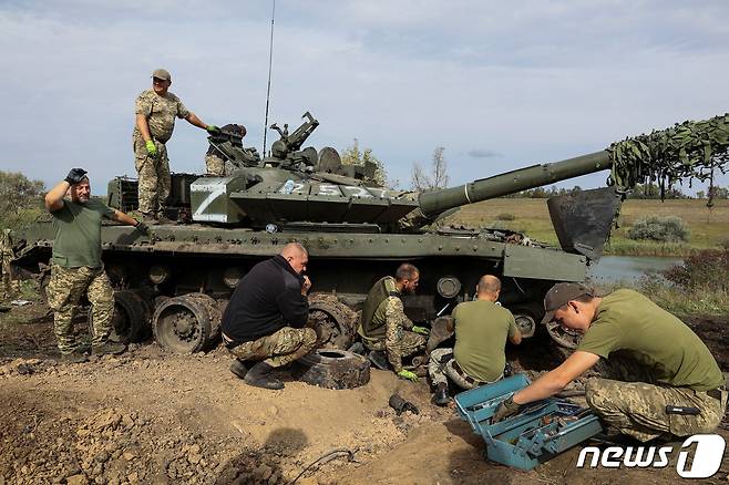 우크라이나 군인들이 20일(현지시간) 우크라이나 하르키우 지역 러시아 접경 지역에서 러시아군 탱크를 노획해 수리하고 있다. ⓒ 로이터=뉴스1 ⓒ News1 김민수 기자