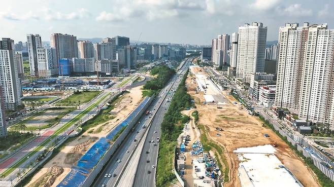 경부고속도로 지하화 공사가 한창인 경기 화성시 동탄신도시 SRT 동탄역 일대. 사업이 끝나는 내년이면 도로는 지하로 들어가고 지상은 대형 녹지공간으로 탈바꿈한다. 동탄신도시 서쪽 주민들도 그동안 고속도로에 가로막혔던 동탄역을 걸어서 이용할 수 있게 된다. 동탄역에는 GTX-A노선, 인덕원~동탄선 등도 추가로 개통한다. /현대건설