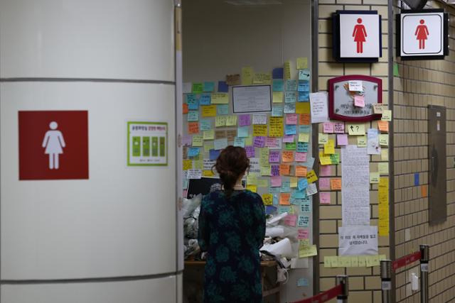 지난 20일 오전 '역무원 스토킹 피살사건'이 발생한 서울 지하철 2호선 신당역에서 한 시민이 여자화장실 입구에 마련된 추모 공간을 찾아 고인을 추모하고 있다. 연합뉴스