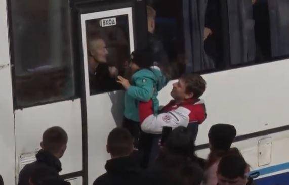 22일 러시아 동부 사하공화국 네륜그리에서 한 남성이 징집 버스에 탄 채 아이와 마지막 인사를 나누고 있다. 전날 블라디미르 푸틴 러시아 대통령은 부분 동원령을 내렸다. 트위터 계정 @poli_golobokova 영상 캡처