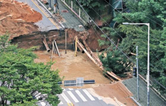 지난해 8월 경기도 구리시 교문동의 아파트 단지 앞에 생긴 대형 싱크홀. 근처에서 진행 중인 지하철 8호선 공사에 따른 지반 약화가 원인으로 추정됐다. 뉴스1