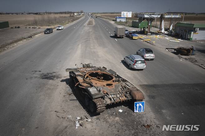 [키이우(우크라이나)=AP/뉴시스]15일(현지시간) 우크라이나 키이우로 가는 도로 모습. 최근 전투에서 파괴된 러시아 탱크가 도로 한가운데 서 있다. 2022.04.16.photo@newsis.com