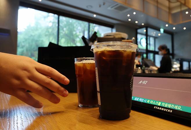 주요 커피전문점과 패스트푸드점에서 한해 소비되는 일회용컵이 증가하는 가운데 13일 서울의 한 커피 전문점에서 한 시민이 커피를 일회용 컵에 담아 가져가고 있다. ⓒ연합뉴스
