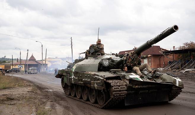 15일(현지시각) 우크라이나 정비공이 러시아로부터 되찾은 이지움 지역에서 러시아군이 버리고 간 탱크를 운전하고 있다. /EPA 연합