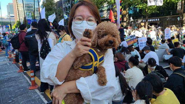 24일 기후정의행진에 참여한 김아리씨가 반려견과 함께 손을 흔들고 있다. 이유진 기자
