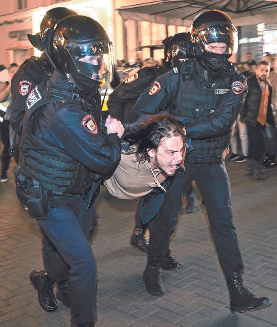 푸틴 대통령이 국민 동원령을 내린 21일 모스크바 시내에서 반전 시위대가 경찰에 끌려가며 구호를 외치고 있다. 국민 동원령을 내린 건 2차 대전 이후 처음이다. 이번 징집 대상자는 30만 명이다.[AFP=연합뉴스]