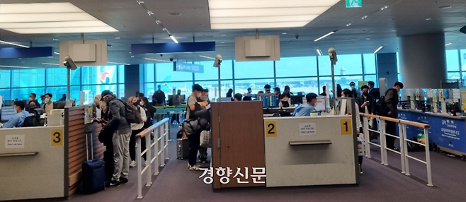 지난 20일 인천공항에 도착한 여행객들이 2층 입국장에 마련된 검역소에서 마스크를 쓰고 검역신고서를 제출하고 있다.