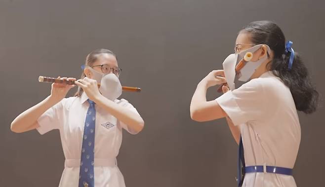 홍콩 교육국이 공개한 영상에는 학생들이 덮개가 달린 마스크를 쓴 채 피리를 연주하고 있다. / 유튜브