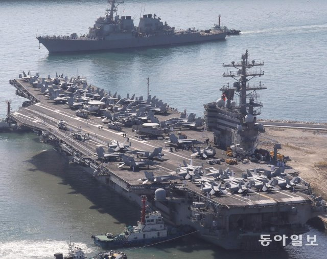 미 해군의 핵추진 항공모함  로널드 레이건함 (CVN-76)(앞쪽)과 이지스 구축함  배리함 (DDG-52)(뒤쪽) 등 항모강습단이 23일 오전 부산 남구 해군작전사령부기지에 입항하고 있다.  떠다니는 군사기지 로 불리는 이 항모는 전투기 FA-18(슈퍼호넷), F-35C 전투기 등 80여 대의 항공기를 탑재하고 있다. 부산=박경모 기자 momo@donga.com