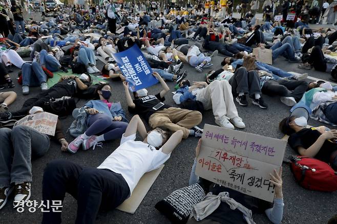지난 24일 서울시청 일대에서 열린 기후정의행진에서 참가자들이 ‘죽은 듯이 눕는다’는 뜻의 다이인(die-in) 시위를 하고 있다. 문재원 기자