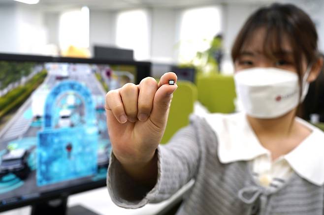 LG유플러스(LGU+)와 ICTK홀딩스가 양자내성암호(PQC) 기술과 물리적 복제 방지기능(PUF)을 적용한 e심(eSIM·내장형 가입자식별모듈)을 개발했다고 26일 밝혔다. 사진은 LGU+ 직원이 개발한 e심을 손에 들고 보여주는 모습. /LG유플러스 제공