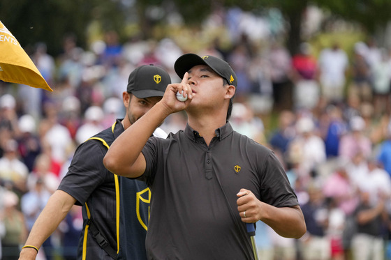 Sep 25, 2022; Charlotte, North Carolina, USA; International Team golfer Si Woo Kim (right) reacts after making his putt on the 15th green in front of caddie Manuel Villegas (left) during the singles match play of the Presidents Cup golf tournament at Quail Hollow Club. Mandatory Credit: Jim Dedmon-USA TODAY Sports  〈저작권자(c) 연합뉴스, 무단 전재-재배포 금지〉