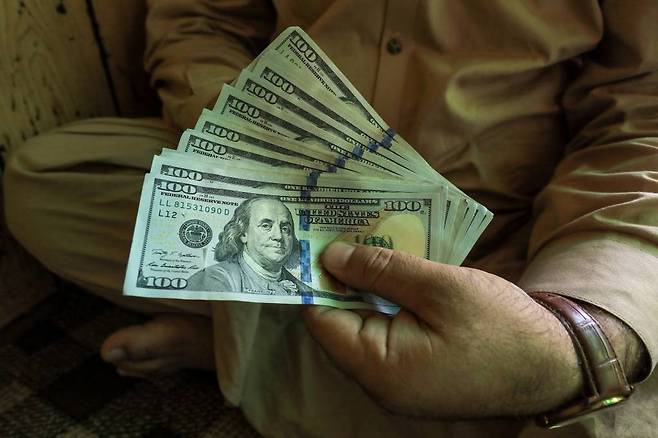 A trader displays U.S. dollar banknotes at a currency exchange booth in Peshawar, Pakistan September 15, 2021. REUTERS/Fayaz Aziz/File Photo /로이터=뉴스1