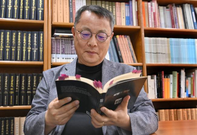‘음식 인문학자’인 주영하 한국학중앙연구원 교수가 지난 16일 경기 성남시 연구실에서 시드니 민츠의 ‘설탕과 권력’을 들여다보고 있다.  신창섭 기자