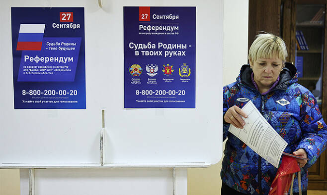 23일(현지시간) 러시아 수도 모스크바의 도네츠크인민공화국(DPR) 대사관에서 한 시민이 우크라이나 점령지의 러시아 귀속 여부를 결정짓는 투표용지를 들고 있다. 모스크바=타스연합뉴스