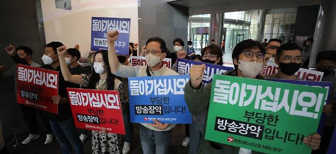 국민의힘이 윤석열 대통령 해외순방 관련 보도와 관련해 MBC를 항의 방문한 가운데, 28일 서울 마포구 MBC문화방송 본사에서 전국언론노동조합 MBC본부 노조원들이 피켓을 들고 구호를 외치고 있다.(사진=연합뉴스)