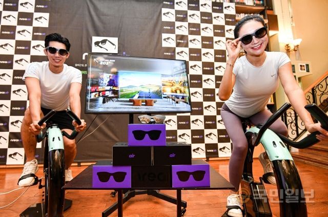 28일 서울 강남구 최인아책방에서 열린 AR(증강현실) 글라스 엔리얼 에어 출시 행사에서 엔리얼 에어를 착용한 모델들이 아크온 실내 자전거를 타며 운동을 하고 있다.