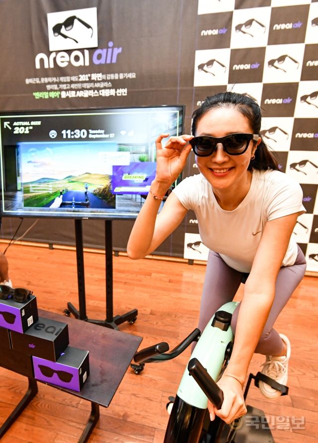 28일 서울 강남구 최인아책방에서 열린 AR(증강현실) 글라스 엔리얼 에어 출시 행사에서 엔리얼 에어를 착용한 모델들이 아크온 실내 자전거를 타며 운동을 하고 있다.