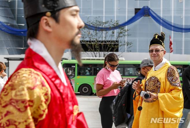 [서울=뉴시스] 정병혁 기자 = 28일 오전 서울 종로구 광화문광장에서 이동 중인 세종대왕 어가행차 옆으로 한복을 입은 외국인이 세종대왕을 바라보고 있다. 2022.09.28. jhope@newsis.com