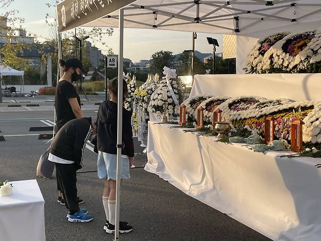 [뉴시스=대전]초등학생과  부모가 대전 현대 아웃렛 화재 현장에 마련된 합동 분향소에서 조문을 하고 있다. 2022.09.28.ssong1007@newsis.com *재판매 및 DB 금지