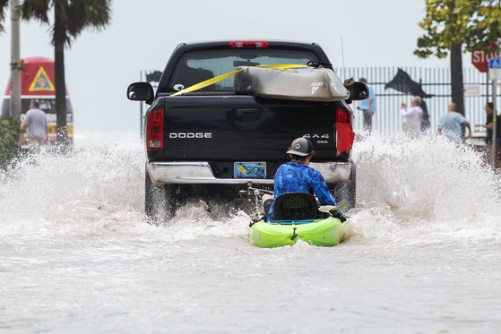 28일 오후(현지시간) 플로리다주 키웨스트에서 한 주민이 허리케인 이언이 동반한 폭우로 도로가 물에 잠기자 트럭에 매단 카약을 타고 대피하고 있다. AP=연합뉴스