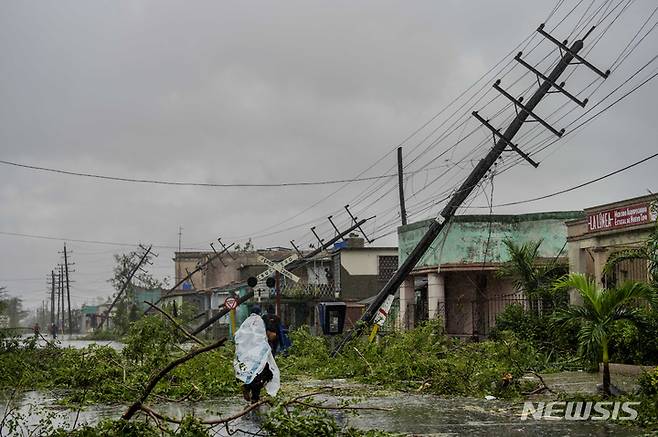 [피나르 델 리오=AP/뉴시스] 27일(현지시간) 쿠바 피나르 델 리오 거리 저신주들이 허리케인 이언으로 가옥에 쓰러져 있다. 2022.09.28.