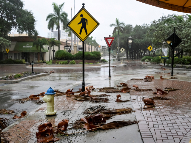 FILE PHOTO: Downed palm fronds collect on an empty downtown intersection as Hurricane Ian approaches Florida?s Gulf Coast in Sarasota, Florida, U.S. September 28, 2022. REUTERS/Steve Nesius/File Photo