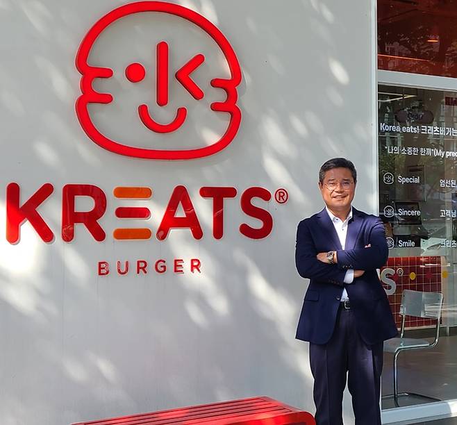 서진덕 본촌치킨 창업자가 크리츠버거 서울 강동역점 앞에서 기념 촬영을 하고 있다. 그는 본촌치킨 매장을 미국 등 해외에서만 400개까지 늘렸지만 2018년 회사 지분 55%를 매각했다. 그리고 지난 여름 서울 강동역에 크리츠버거라는 새로운 브랜드의 매장을 열었다. "본촌치킨을 국내에는 알리지 못한 아쉬움을 크리츠버거로 만회할 것"이라고 했다. /크리츠에프앤비