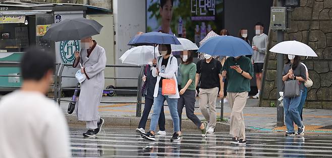 서울 서대문구 연세대 앞 횡단보도에서 우산을 쓴 시민들이 길을 지나고 있다. [연합]