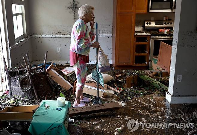 허리케인은 지나갔지만 막막한 복구작업 (포트마이어스[미 플로리다주] AFP=연합뉴스) 2022년 9월 29일(현지시간) 허리케인 이언이 강타한 플로리다 포트마이어스의 주민 스테디 스쿠데리가 침수된 아파트에서 청소 도구를 들고 복구작업을 엄두도 못낸 채 망연자실 서 있다. 2022.10.1