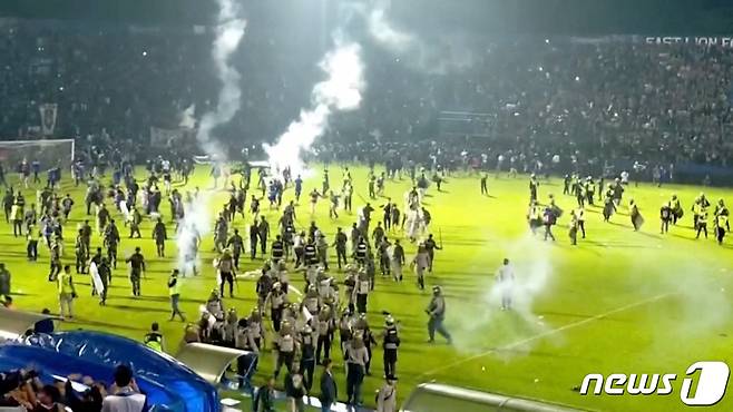 1일(현지시간) 인도네시아 동부 자바 말랑 리젠시의 칸주루한 구장에서 '아르마 FC'와 '페르세바야 수라바야' 축구팀의 경기가 끝난 후 패배에 분노한 관중들이 그라운드로 난입하고 있다. 로이터‧AFP 통신에 따르면 이날 경기에서 패한 아르마 FC 팬들이 경기장에 난입해 이를 진압하기 위해 경찰이 최루탄을 발사하는 과정에서 이를 피하려는 관중들이 몰려 최소 129명이 압사하거나 질식사했으며 부상자는 180명으로 추산되고 있다. ⓒ 로이터=뉴스1 ⓒ News1 박정호 기자