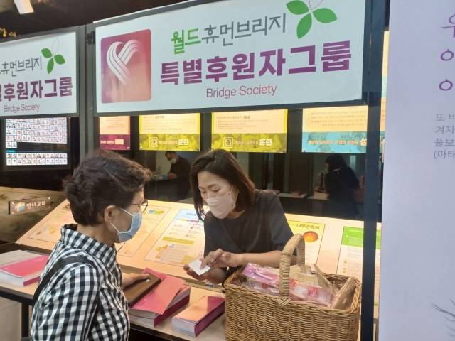 월드휴먼브리지 관계자가 2일 경기도 성남 만나교회에서 한 성도에게 유산 기부 센터인 브리지소사이어티를 소개하고 있다. 월드휴먼브리지 제공