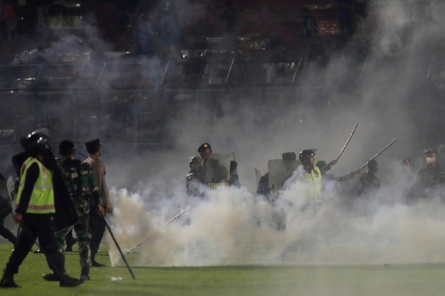 1일 인도네시아 동자바 말랑 칸주루한 스타디움에서 열린 축구경기 도중 경찰과 군인들이 최루탄 연기 속에 서 있다. AP 뉴시스