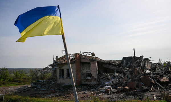 우크라이나 동부 이지윰 근처 파괴된 집 앞에 우크라이나 국기가 걸려 있다. AFP연합뉴스
