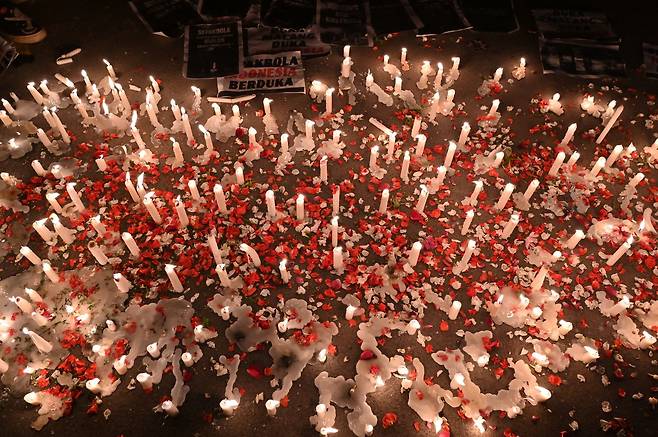 2일(현지 시각) 인도네시아 자카르타에 이번 참사의 희생자들을 추모하는 촛불과 꽃잎들이 놓여있다./AFP 연합뉴스