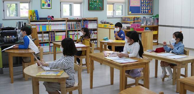 지난 2020년 5월 6일 경남 김해 관동초등학교에서 1학년 학생들이 마스크를 낀 채 거리를 두고 앉아 돌봄교실 수업을 듣고 있다. 연합뉴스