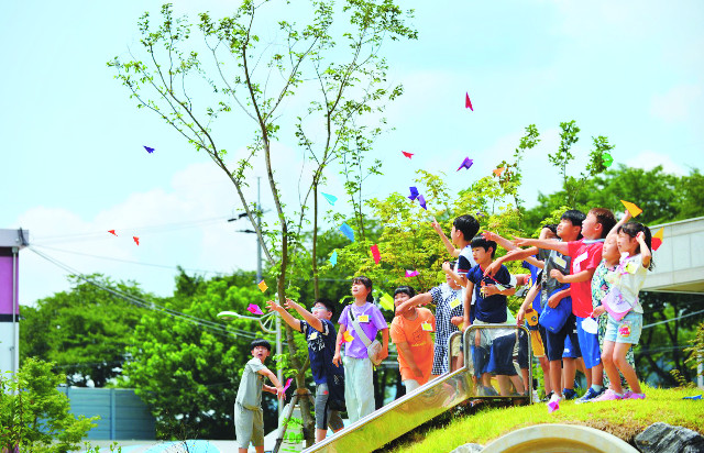 경남 밀양시 밀주초등학교 학생들이 마을학교에서 진행한 종이접기 수업 뒤 자신이 접은  종이비행기를 학교 운동장에서 날리고 있다. 밀주초 제공