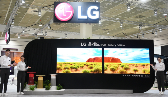 모델들이 4일 서울 강남구 코엑스에서 개막한 ‘한국전자전(KES 2022)’ LG전자 부스에서 세계 최대 97인치 올레드 TV를 소개하고 있다. LG전자 제공